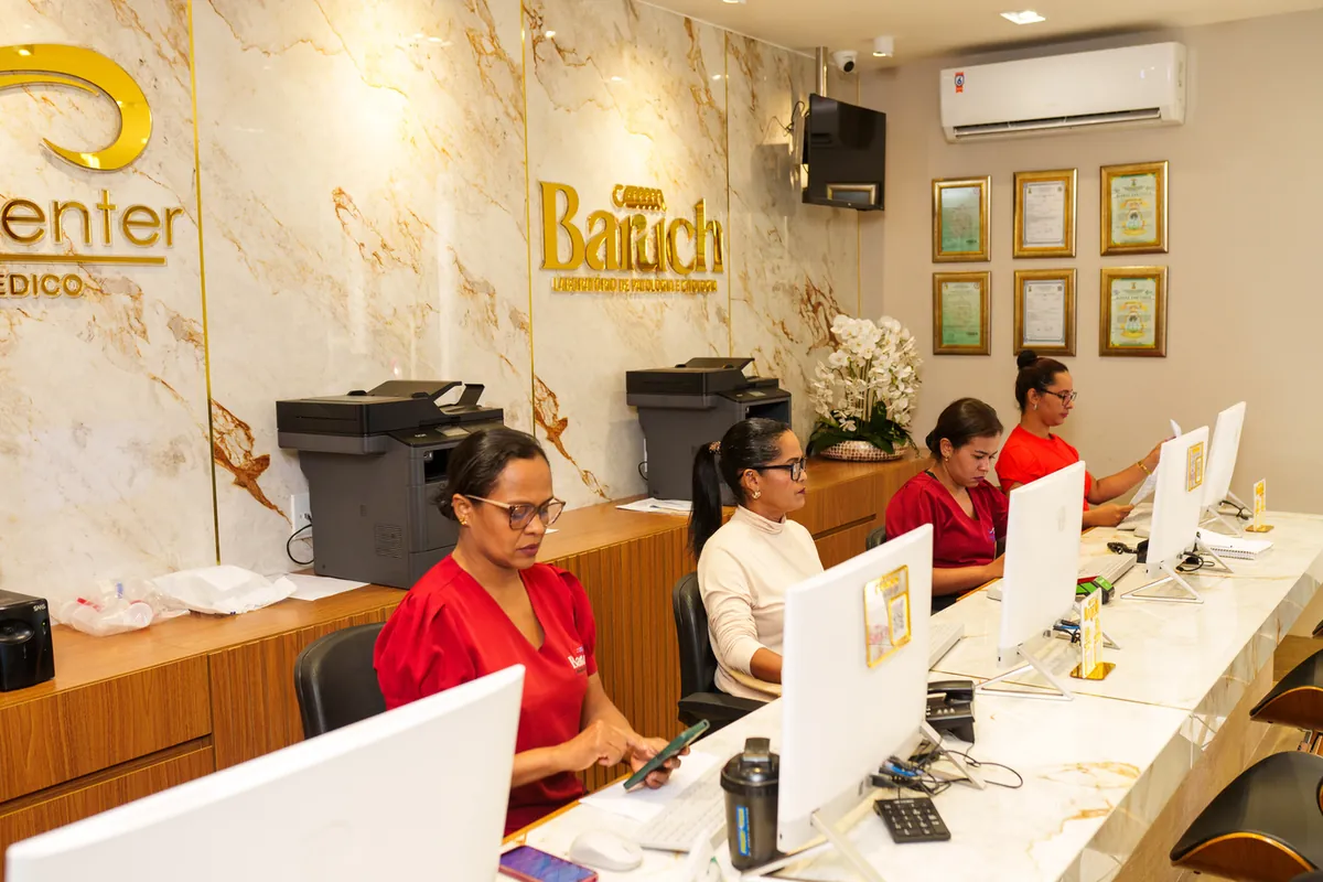 Recepção com equipe atendendo pacientes no balcão